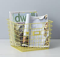 Some magazines are put into a yellow powder coated wire storage basket