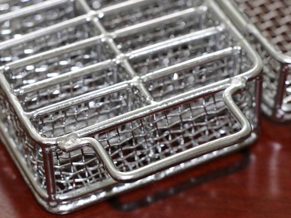 A stainless steel double layer ultrasonic cleaning baskets on the table.